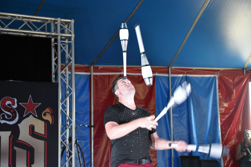 Michael Dubois is performing juggling while balancing the club on his forehead on August 3.